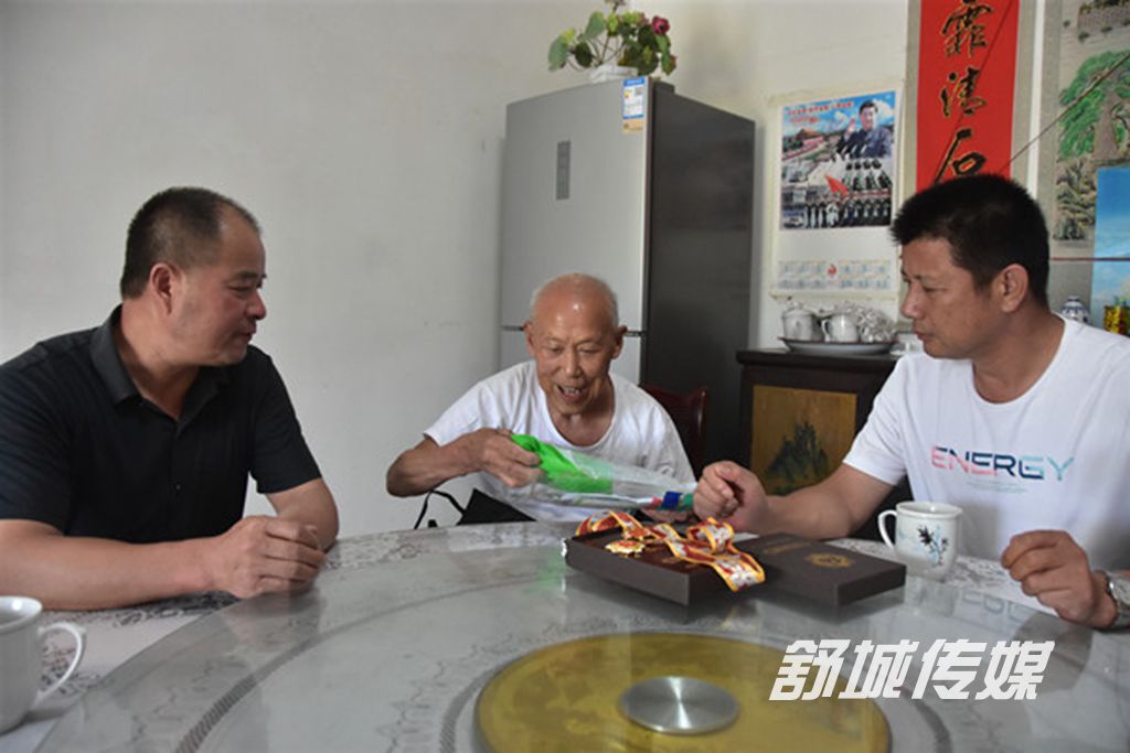 余一和在向村两委干部展示奖章.JPG